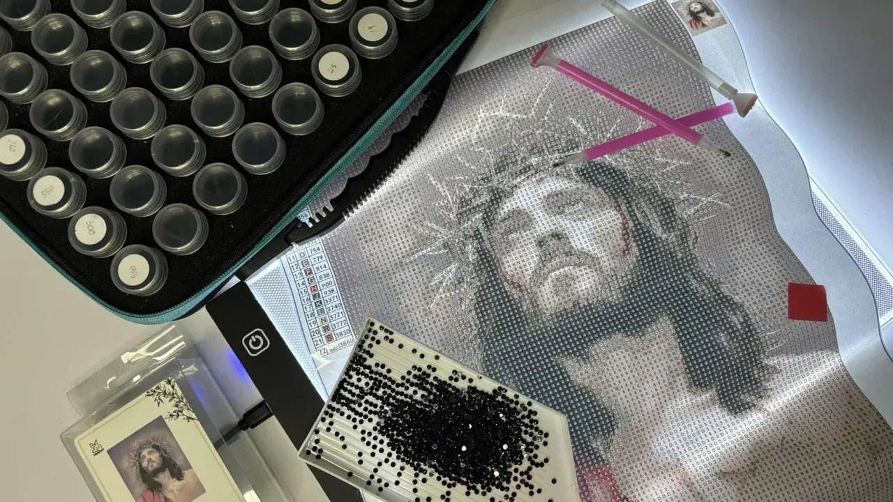 Zestaw do haftu diamentowego: płótno z wizerunkiem Jezusa, pojemniczki z diamencikami, tacka i pisaki. Jak zrobić haft diamentowy?