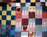 Kolorowy patchwork, czyli technika łączenia skrawków materiału, tworzy wzory z jabłkami, flagami USA i kwiatami.