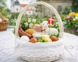 Biały koszyczek wielkanocny dla dziecka: jajka, kiełbasa, chleb, masło, baranek z flagą. Idealne co do koszyczka wielkanocnego dla dziecka.