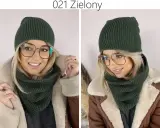 Kobieta w zielonym komplecie: czapka i komin. Zastanawiasz się, jaki ścieg na szalik wybrać? Ten gruby, warkoczowy ścieg wygląda świetnie!
