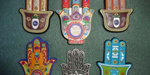 Kolekcja ozdobnych amuletów w kształcie dłoni Fatimy. Każdy **znak hamsa znaczenie** ma unikalne, symboliczne wzory i kolory, chroniące przed złym okiem.