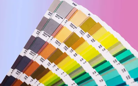 Próbnik kolorów Pantone prezentuje bogactwo barw, od stonowanych szarości po jaskrawe zielenie i żółcie. To narzędzie niezbędne w praktycznym zastosowaniu teorii koloru.