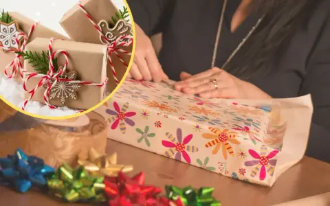 Osoba pakuje prezent w kolorowy papier. W tle widać kilka prezentów w brązowym papierze.