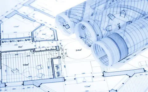 Zrolowane rysunki techniczne z planami architektonicznymi i wymiarami.