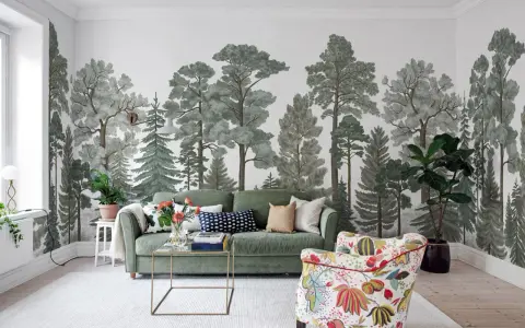 Mural w mieszkaniu z motywem lasu, zielona sofa i kolorowy fotel tworzą przytulną przestrzeń.