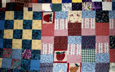 Kolorowy patchwork, czyli technika łączenia skrawków materiału, tworzy wzory z jabłkami, flagami USA i kwiatami.