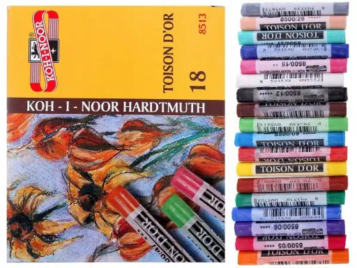 Pudełko z pastelami Koh-i-Noor i stos kolorowych pasteli olejnych.