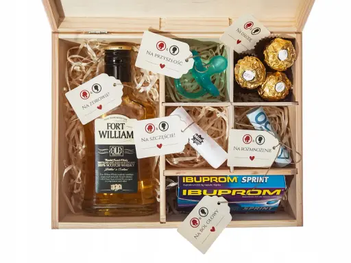 Drewniana skrzynka z zawartością: butelka whisky, smoczek, czekoladki, leki, pieniądze i losy. To idealny **niezbędnik małżeński co włożyć** na szczęście i przyszłość.
