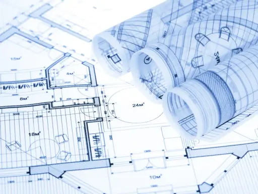 Zrolowane rysunki techniczne z planami architektonicznymi i wymiarami.