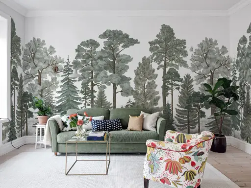 Mural w mieszkaniu z motywem lasu, zielona sofa i kolorowy fotel tworzą przytulną przestrzeń.