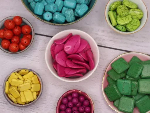 Kilka misek z kolorowymi kamieniami: turkusowymi, zielonymi, żółtymi, różowymi, czerwonymi i fioletowymi.