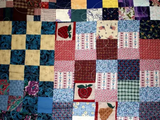 Kolorowy patchwork, czyli technika łączenia skrawków materiału, tworzy wzory z jabłkami, flagami USA i kwiatami.