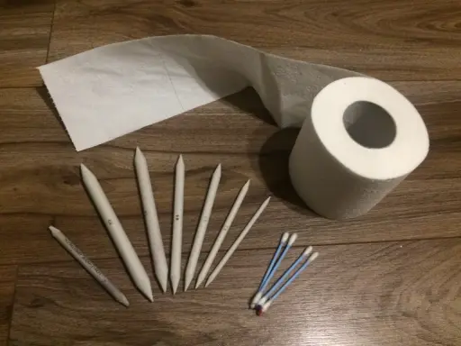 Zestaw narzędzi do rozcierania: wiszer, rolka papieru, patyczki kosmetyczne i grafit.