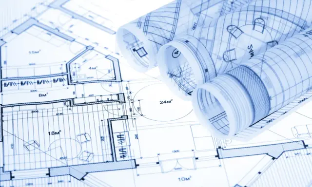 Zrolowane rysunki techniczne z planami architektonicznymi i wymiarami.