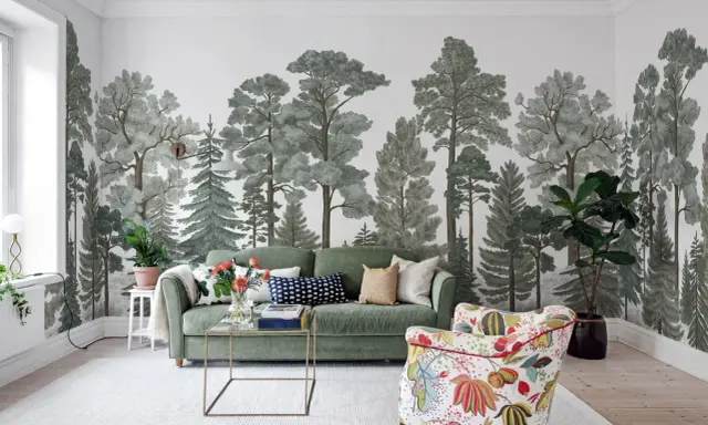 Mural w mieszkaniu z motywem lasu, zielona sofa i kolorowy fotel tworzą przytulną przestrzeń.