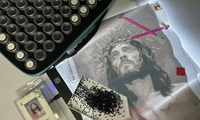 Zestaw do haftu diamentowego: płótno z wizerunkiem Jezusa, pojemniczki z diamencikami, tacka i pisaki. Jak zrobić haft diamentowy?