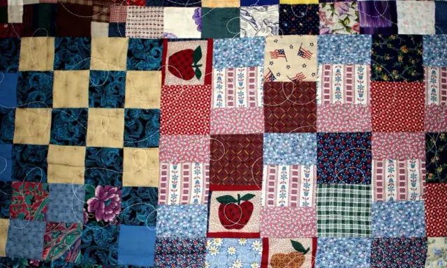 Kolorowy patchwork, czyli technika łączenia skrawków materiału, tworzy wzory z jabłkami, flagami USA i kwiatami.