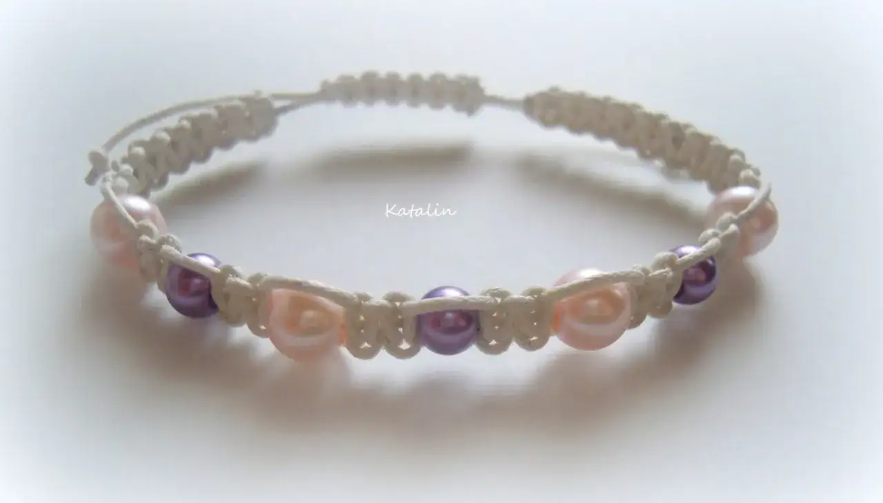 Bransoletka shamballa z perłami w kolorze różowym i fioletowym, wykonana techniką makramy.