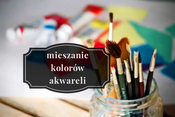 Pędzelki do malowania czekają na mieszanie kolorów akwareli. W tle tubki z farbami i kolorowe płótno.